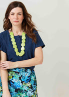 Tabatha Navy Cotton Short Sleeve Velcro Tee paired with a botanic lime necklace- The Able Label